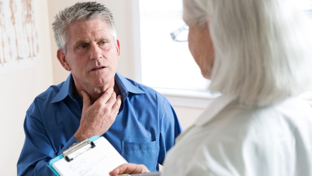 middle aged man describing symptoms to physician